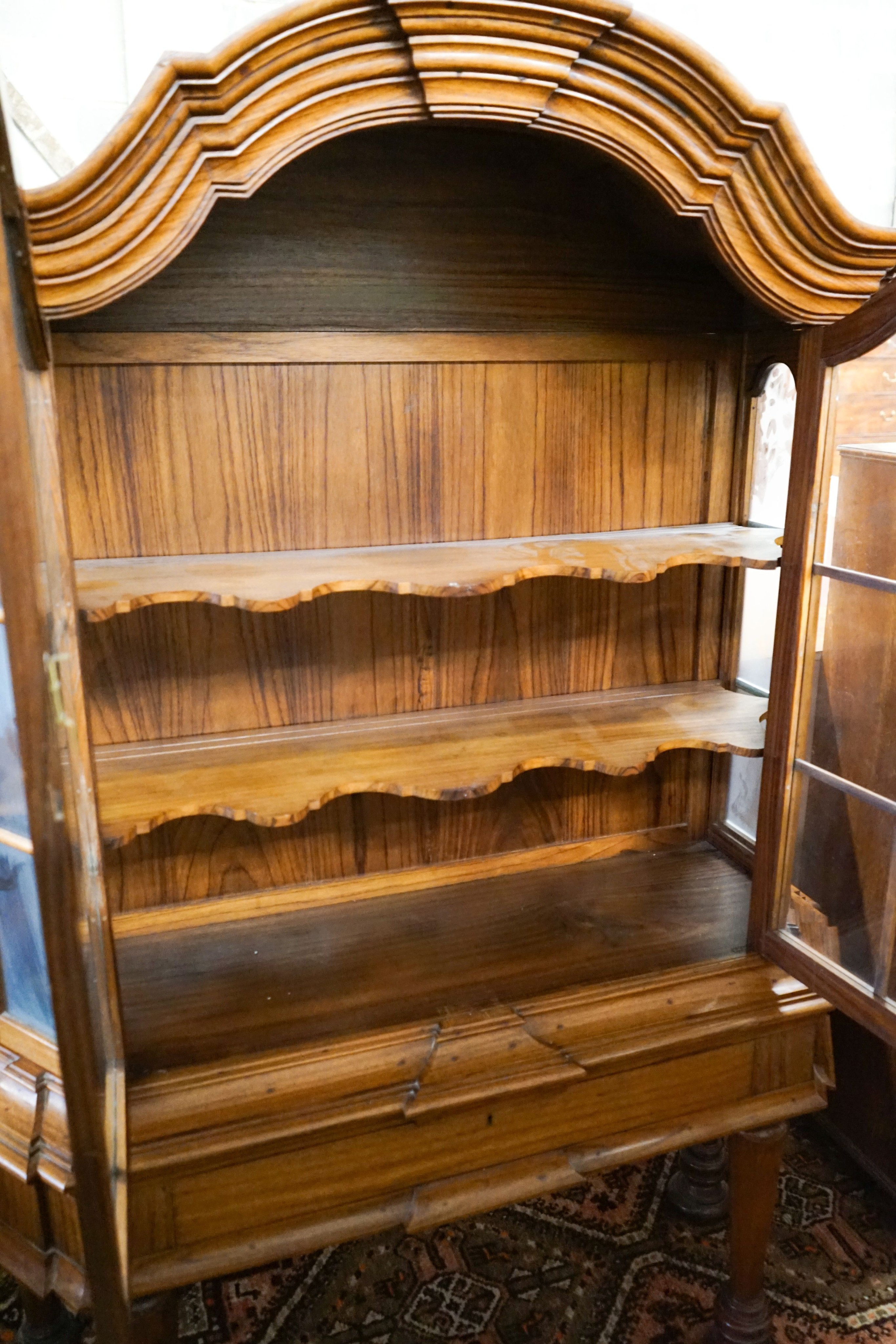 An 18th century style Dutch walnut display case, with double-arched moulded cornice over a pair of astragal-glazed panelled doors, frieze drawer and base with octagonal tapered legs and lion feet, length 132cm, depth 46c